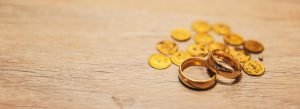 two gold rings with gold coins on a wooden table